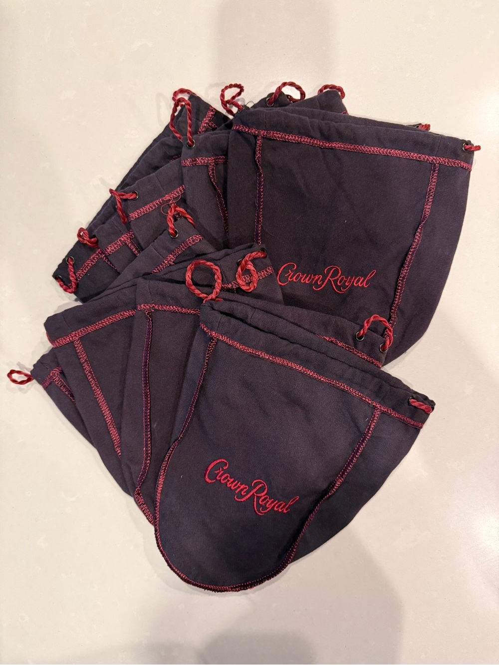9 Dark Purple Crown Royal bags with red trim and embroidered logo